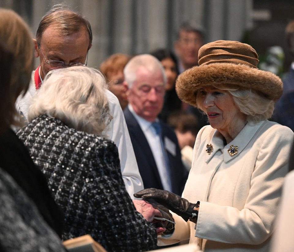 Britain's Queen Camilla hands out the Maundy Money during the Royal Maundy Service where she distributes the money to 75 men and 75 women, mirroring the age of the monarch, in Worcester Cathedral, western England on March 28, 2024, to thank them for their outstanding Christian service and for making a difference to the lives of people in their local communities. Maundy Thursday is the Christian holy day falling on the Thursday before Easter. The monarch commemorates Maundy by offering 'alms' to senior citizens. Each recipient receives two purses, one red and one white. (Photo by JUSTIN TALLIS / POOL / AFP) (Photo by JUSTIN TALLIS/POOL/AFP via Getty Images)