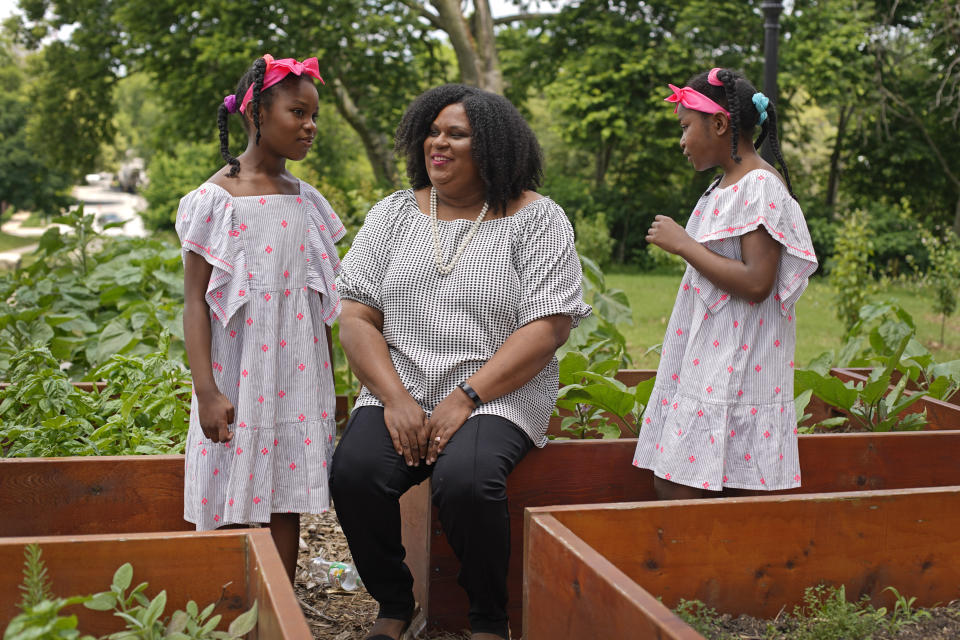 Emily Brown talks with her daughters Hannah, 7, left, and Catherine, 9, outside her office Wednesday, June 9, 2021, in Kansas City, Mo. Brown runs a nonprofit service to help families with food allergies access safe and healthy foods which she started after having difficulty obtaining food for her daughters who have numerous food allergies. (AP Photo/Charlie Riedel)