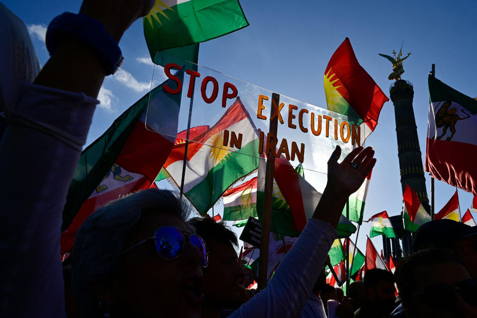 Protesters hold up a placard reading 'Stop Execution in Iran' as they take part in a rally in support of the demonstrations in Iran, in front of the Victory Column in Berlin on Oct. 22, 2022.<span class="copyright">John Macdougall—AFP/Getty Images</span>