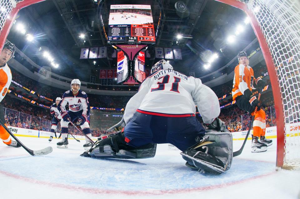 Philadelphia Flyers' Owen Tippett, right, shots the puck past Columbus Blue Jackets goalie Michael Hutchinson, center, for an overtime goal in an NHL hockey game,Tuesday, April 11, 2023, in Philadelphia. The Flyers won 4-3. (AP Photo/Chris Szagola)