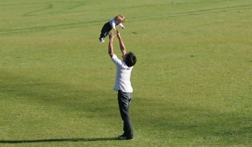 A young father plays with his child in a park in Berlin. Germany plans to reward parents who look after children at home but opponents say "Herdpraemie", or literally "oven bonus", is out-dated.Concerned by its rapidly ageing population, Germany has been trying since 2005 to lift its low birth rate with paid parental leave in a child's first year and improved childcare facilities