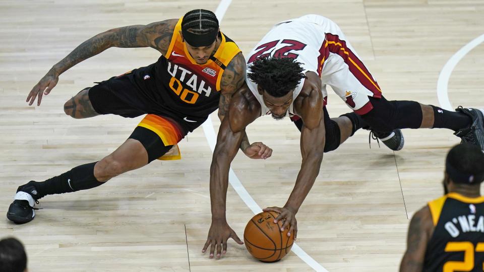 Utah Jazz guard Jordan Clarkson (00) and Miami Heat forward Jimmy Butler (22) battle for a the ball in the second half during an NBA basketball game Saturday, Feb. 13, 2021, in Salt Lake City. (AP Photo/Rick Bowmer)