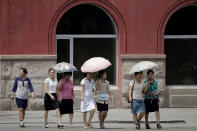 <p>Women carry parasols as they walk down the street of downtown Pyongyang on July 26, 2017, North Korea. (Photo: Wong Maye-E/AP) </p>