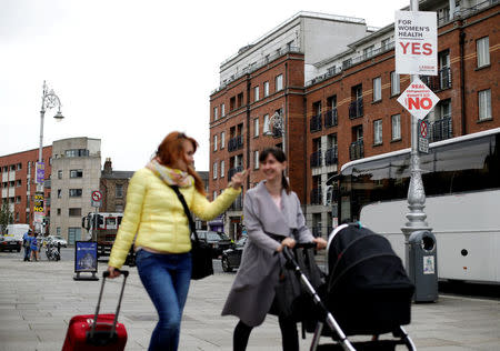 Woman walk past pro-choice and pro-life posters in the city centre of Dublin, Ireland, May 22, 2018. REUTERS/Max Rossi