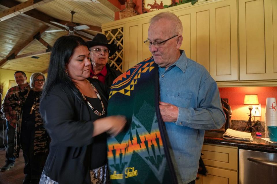 Racheal Starr, secretary-treasurer of the Tonkawa tribe, presents Leon Herzog with a Pendleton blanket during a private lunch that followed the exchange of ownership papers. Herzog and his family sold the Tonkawa the 60 acres that includes Sugarloaf Mountain, which they hold sacred.