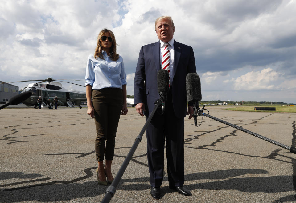 President Donald Trump, with first lady Melania Trump, speaks to the media before boarding Air Force One in Morristown, N.J., Sunday, Aug. 4, 2019. (AP Photo/Jacquelyn Martin)