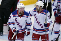 New York Rangers' Alexis Lafrenière, left, celebrates his goal with teammate Anthony Bitetto during the second period of the NHL hockey game against the New Jersey Devils in Newark, N.J., Sunday, April 18, 2021. (AP Photo/Seth Wenig)