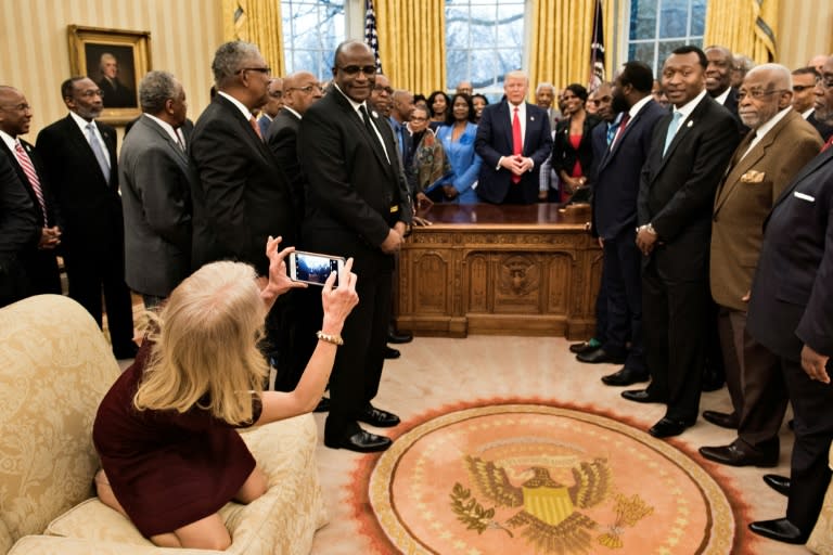 Kellyanne Conway takes a photo as US President Donald Trump and leaders of historically black universities and colleges in the Oval Office