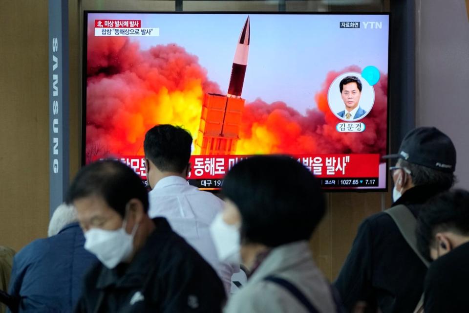 South Koreans watch a news program showing a file image of the North’s missile launch  (AP)