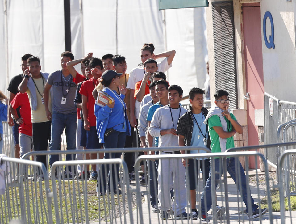 FILE - In this April 19, 2019 file photo, Children line up to enter a tent at the Homestead Temporary Shelter for Unaccompanied Children in Homestead, Fla. Immigrant advocates say the U.S. government is allowing migrant children at a Florida facility to languish in “prison-like conditions” after crossing the U.S.-Mexico border instead of releasing them promptly to family as required by federal rules. A court filing Friday, May 31, 2019 revealed conditions inside the Homestead, Florida, facility that has become the nation’s biggest location for detaining immigrant children. (AP Photo/Wilfredo Lee, File)