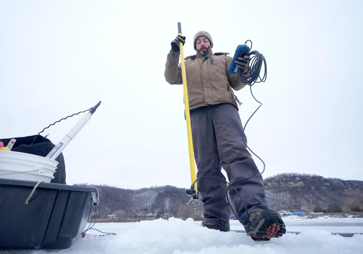 Jeremy King, a DNR water quality technician, uses a device to measure the turbulence of the water in the Mississippi River in Alma, Wisconsin in mid-February.  The DNR's Mississippi River team are studying fish in the backwaters of the upper river that are getting "flushed" out of their habitat by high, fast-moving water over the past decade and trying to determine adaptations so that ecosystems for those fish (bass & bluegill) aren’t destroyed.