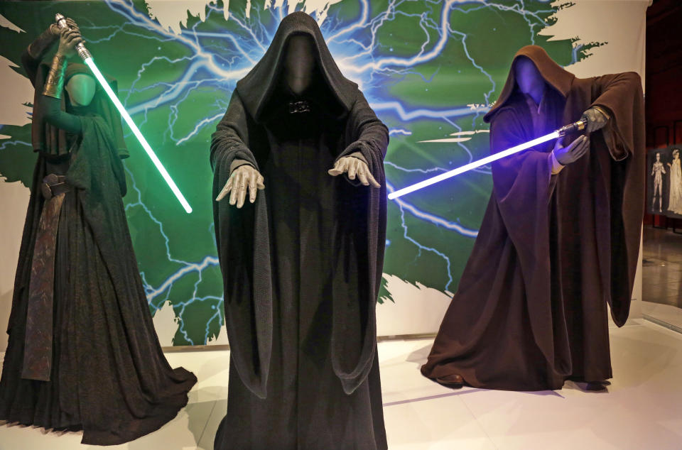 In this photo taken Thursday, Jan. 29, 2015, Sith robes and lightsabers are displayed as part of an exhibit on the costumes of Star Wars at Seattle's EMP Museum. The creators of the new exhibit, with 60 original costumes from the six Star Wars movies, are hoping to gather geeks, fashionistas and movie fans together to discuss how clothing helps set the scene. The exhibit, Rebel, Jedi, Princess, Queen: Star Wars and the Power of Costume, will be in Seattle through early October and then travel across the United States through 2020. (AP Photo/Elaine Thompson)