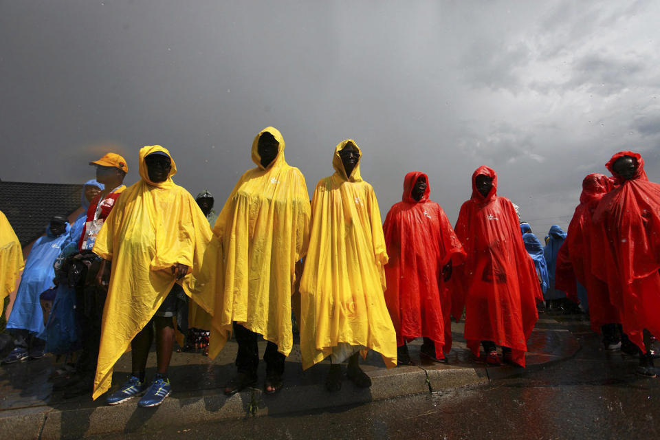 Pilgrims covered in raincoats wait for Pope Francis