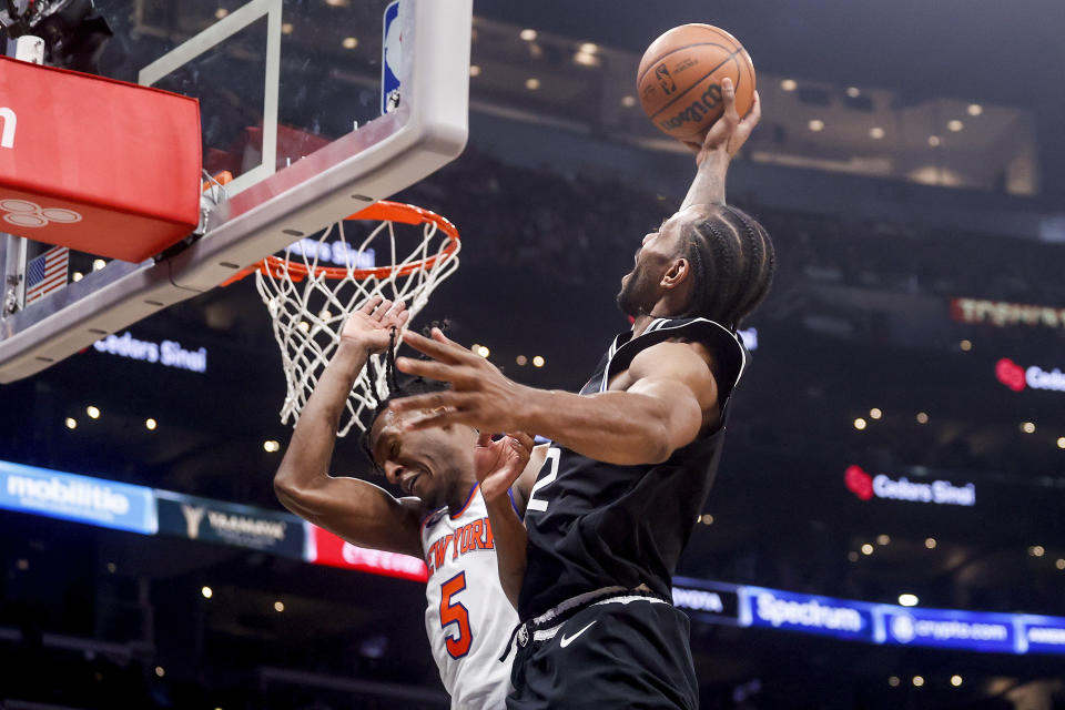 Los Angeles Clippers forward Kawhi Leonard, right, gies up for a dunk against New York Knicks guard Immanuel Quckley (5) during the second half of an NBA basketball game Saturday, March 11, 2023, in Los Angeles. (AP Photo/Ringo H.W. Chiu)