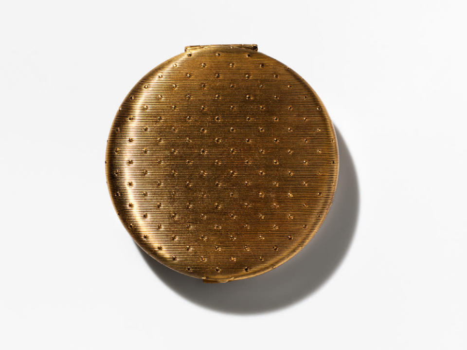 <p>This gold compact with small lines also may have been the first compact ever, and it says New York. The same design was later redone in 1962 and was a bit smaller and the lines go vertically instead of horizontally. Another way to tell them apart is the later one says New York, London, Toronto on it — the brand wasn’t carried at Harrods until 1960. <i>(Photo: Henry Leutwyler)</i></p>
