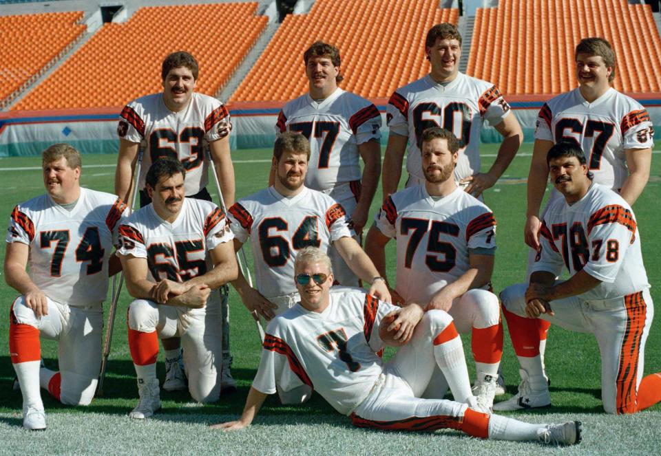 Cincinnati Bengals quarterback Boomer Esiason (7) poses with the Bengals' offensive line in Miami as they turn out for Super Bowl Media Day on Tuesday, Jan. 17, 1989. From left, back row: Joe Walter (63), Herb Wester (77), Dave Smith (60), David Douglas (67). Front: Brian Blados (74), Max Montoya (65), Bruce Kozerski (64), Bruce Reimers (75), Anthony Munoz (78).