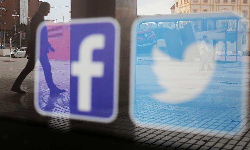 Facebook and Twitter logos are seen on a shop window