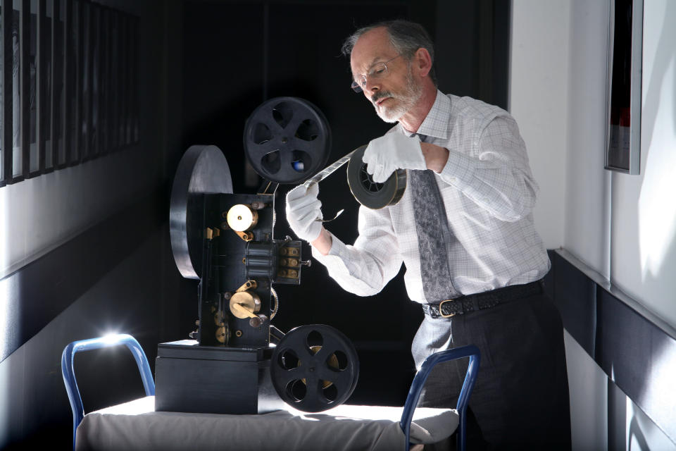 In this undated photo released by Britain's National Media Museum, Michael Harvey, curator of cinematography at the National Media Museum, Bradford, is depicted with a colour projector, as some of the earliest colour moving pictures ever made have been rediscovered after more than 100 years. The footage, made by cinematic pioneer Edward Turner in around 1901, was found in the archives of the National Media Museum in Bradford and with the help of experts at the BFI National Archive was transformed into watchable digital files. (AP Photo/ National Media Museum)