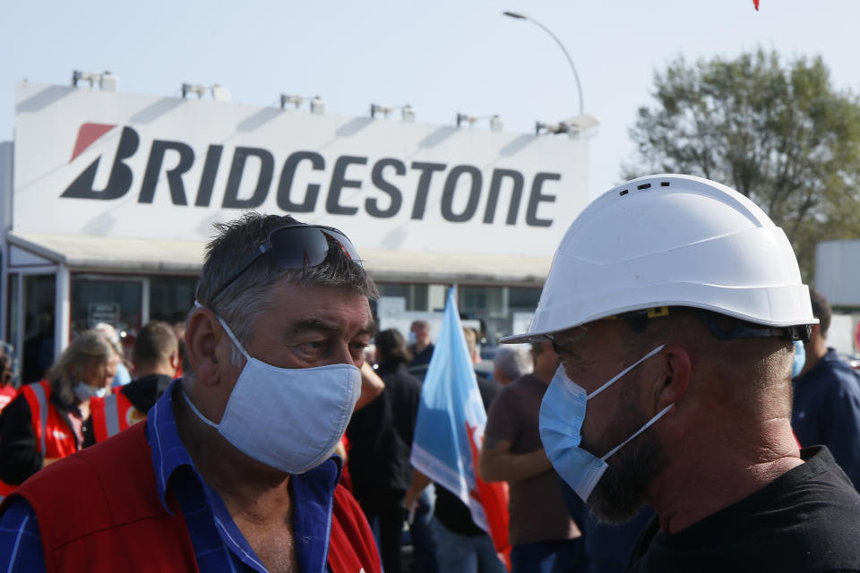 Bridgestone employees gather outside the tire factory of Bethune, northern France, Thursday, Sept.17, 2020. Workers protest over the Japan-based company's decision to close the plant and lay off all its nearly 900 workers. Bridgestone argues the factory is no longer competitive globally, but unions and French politicians accused the company of using the virus-driven economic crisis as a pretext for the closure and not investing in modernizing the plant instead. (AP Photo/Michel Spingler)