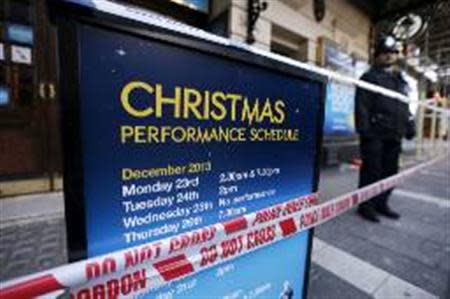 A police officer stands on duty next to a notice board is wrapped in police tape outside the Apollo theatre on the morning after part of it's ceiling collapsed on spectators as they watched a performance, in central London, December 20, 2013.REUTERS/Suzanne Plunkett