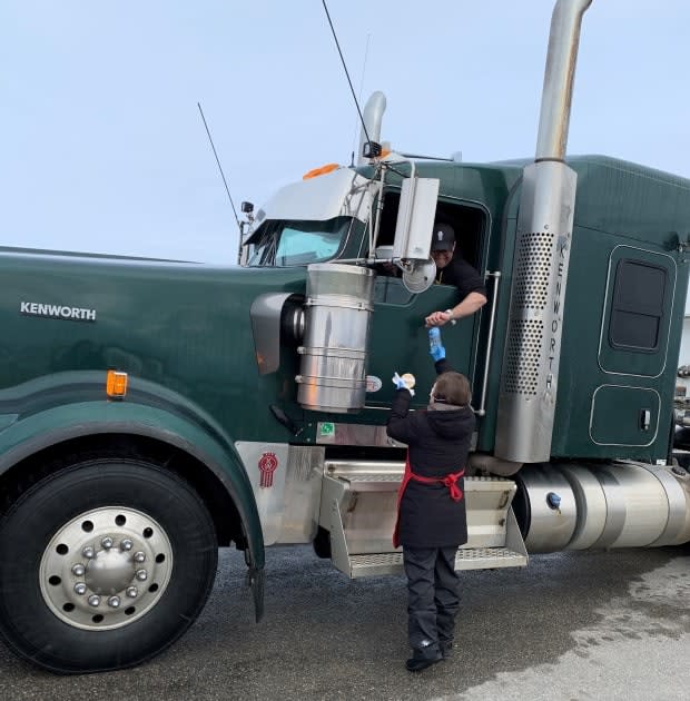 Volunteer Darlene Collier brings a hot meal, one of dozens prepared each day, to a truck driver in April 2020.