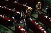 The police take photos at the chamber of the Legislative Council after pro-democracy lawmakers hurled objects during third reading on the controversial national anthem bill in Hong Kong