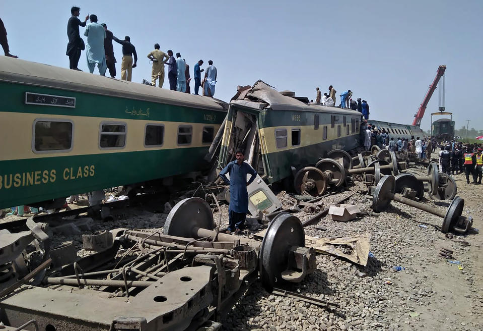 Soldiers and volunteers work at the site of a train collision in Ghotki district in southern Pakistan, Monday, June 7, 2021. Two express trains collided in southern Pakistan early Monday, killing dozens of passengers, authorities said, as rescuers and villagers worked to pull injured people and more bodies from the wreckage. (AP Photo/Waleed Saddique)