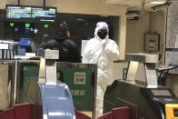 A security officer wears a hazardous materials suit at a subway station in Beijing, Friday, Jan. 24, 2020. China moved to lock down at least three cities with a combined population of more than 18 million in an unprecedented effort to contain the deadly new virus that has sickened hundreds of people and spread to other parts of the world during the busy Lunar New Year holiday. (AP Photo/Yanan Wang)