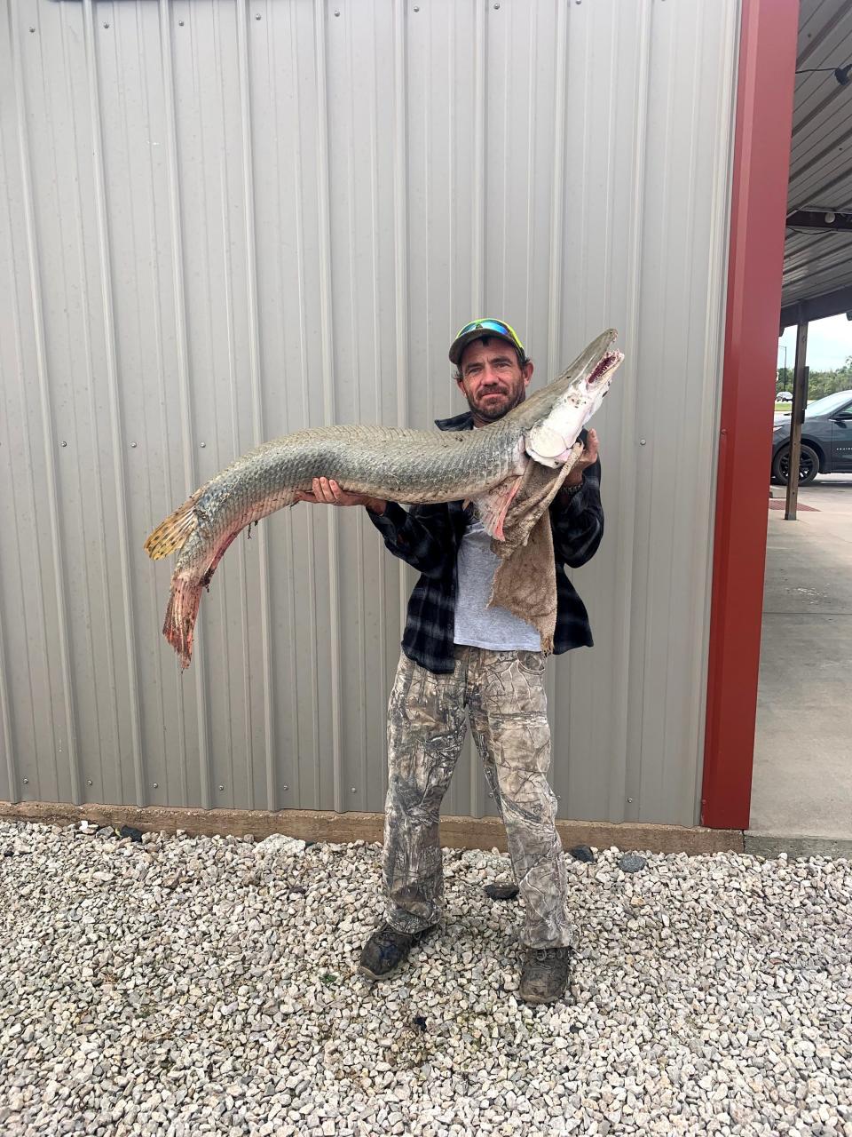 Danny Smith II displays a 39.5-pound Alligator Gar, measuring four feet, six inches, which he caught in the Neosho River in southeast Kansas.