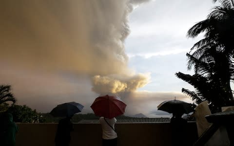 People watch as Taal Volcano erupts near Manila  - Credit: AP Photo/Aaron Favila