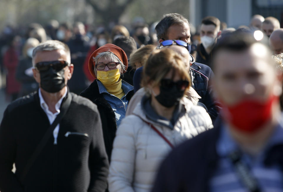 People wait in line to receive a dose of the AstraZeneca vaccine at Belgrade Fair makeshift vaccination center in Belgrade, Serbia, Saturday, March 27, 2021. Thousands of vaccine-seekers from Serbia's neighboring states have flocked to Belgrade after Serbian authorities offered free coronavirus jabs for foreigners if they show up over the weekend. Many arriving with their entire families, long lines of Bosnians, Montenegrins, North Macedonians and even Albanians formed Saturday in front of the main vaccination center in the Serbian capital. (AP Photo/Darko Vojinovic)