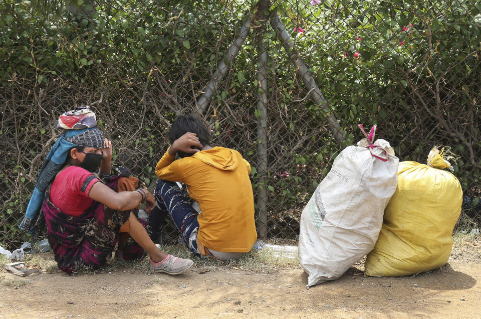 In this Friday, May 8, 2020, photo, migrant workers from Chhattisgarh state take a rest during the journey to their village on foot, hundreds of miles away, during a nationwide lockdown to curb the spread of new coronavirus in Hyderabad, India. Tens of thousands of impoverished migrant workers are on the move across India, walking on highways and railway tracks or riding trucks, buses and crowded trains in blazing heat amid threat to their lives from the coronavirus pandemic. (AP Photo/Mahesh Kumar A.)