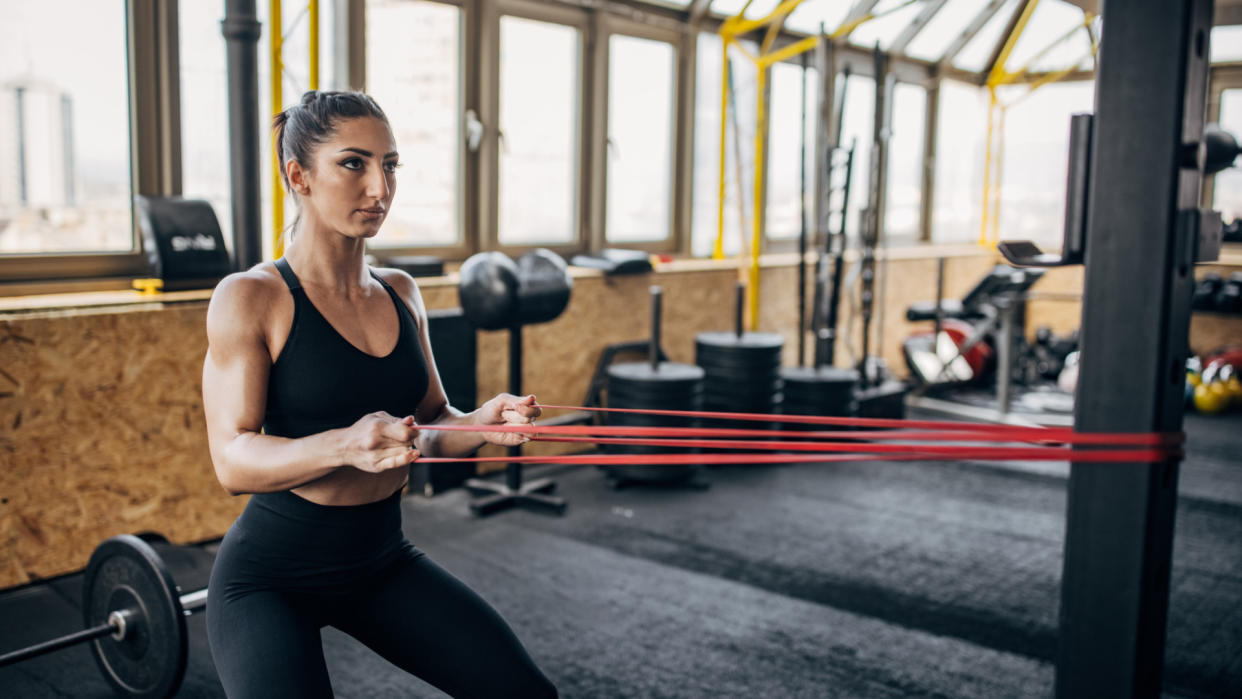  Woman doing resistance band workout. 
