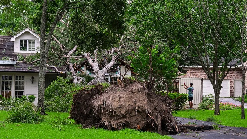 A home is severely damaged by a fallen tree after heavy winds and rains ripped through the region in Houston, Texas, on Friday. - Logan Riely/Getty Images