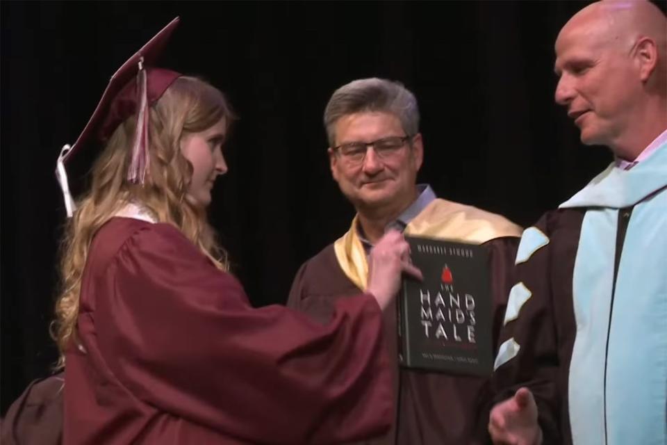 <p>West Ada School District/Youtube</p> Anabelle Jenkins gives superintendent Derek Bub a copy of the graphic novel adaptation of 