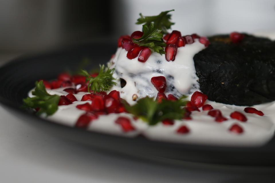 FILE - A chile en nogada sits ready to be delivered to a diner at the Arango restaurant in Mexico City, Aug. 26, 2019. Chiles en nogada is a seasonal dish of mild poblano peppers stuffed with ground pork and fruit, smothered in a sauce of walnut, parsley and pomegranate seeds. The recipe was invented in 1821 by a nun, whose name has been lost to history. (AP Photo/Rebecca Blackwell, File)