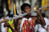 ATTENTION EDITORS - GRAPHIC CONTENT A devotee of the Chinese Bang Neow Shrine with a sword pierced through his cheek takes part in a street procession during the annual vegetarian festival in Phuket October 10, 2013. The festival, featuring face-piercing, spirit mediums, and strict vegetarianism celebrates the local Chinese community's belief that abstinence from meat and various stimulants during the ninth lunar month of the Chinese calendar will help them obtain good health and peace of mind. REUTERS/Athit Perawongmetha (THAILAND - Tags: RELIGION SOCIETY) TEMPLATE OUT