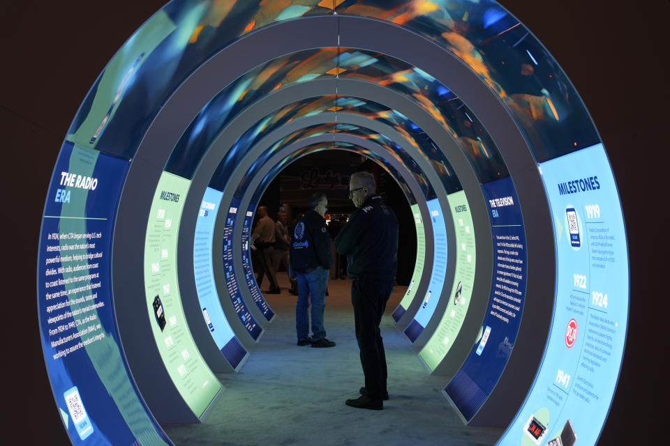 People look at a CES exhibit during the CES tech show Tuesday, Jan. 9, 2024, in Las Vegas. (AP Photo/John Locher)