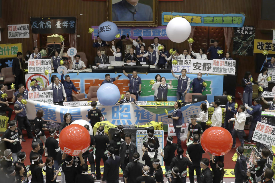 Seguidores de partidos en el gobierno y la oposición se manifiestan en el edificio de la cámara legislativa de Taipéi, Taiwán, el martes 28 de mayo de 2024. (AP Foto/Chiang Ying-ying)