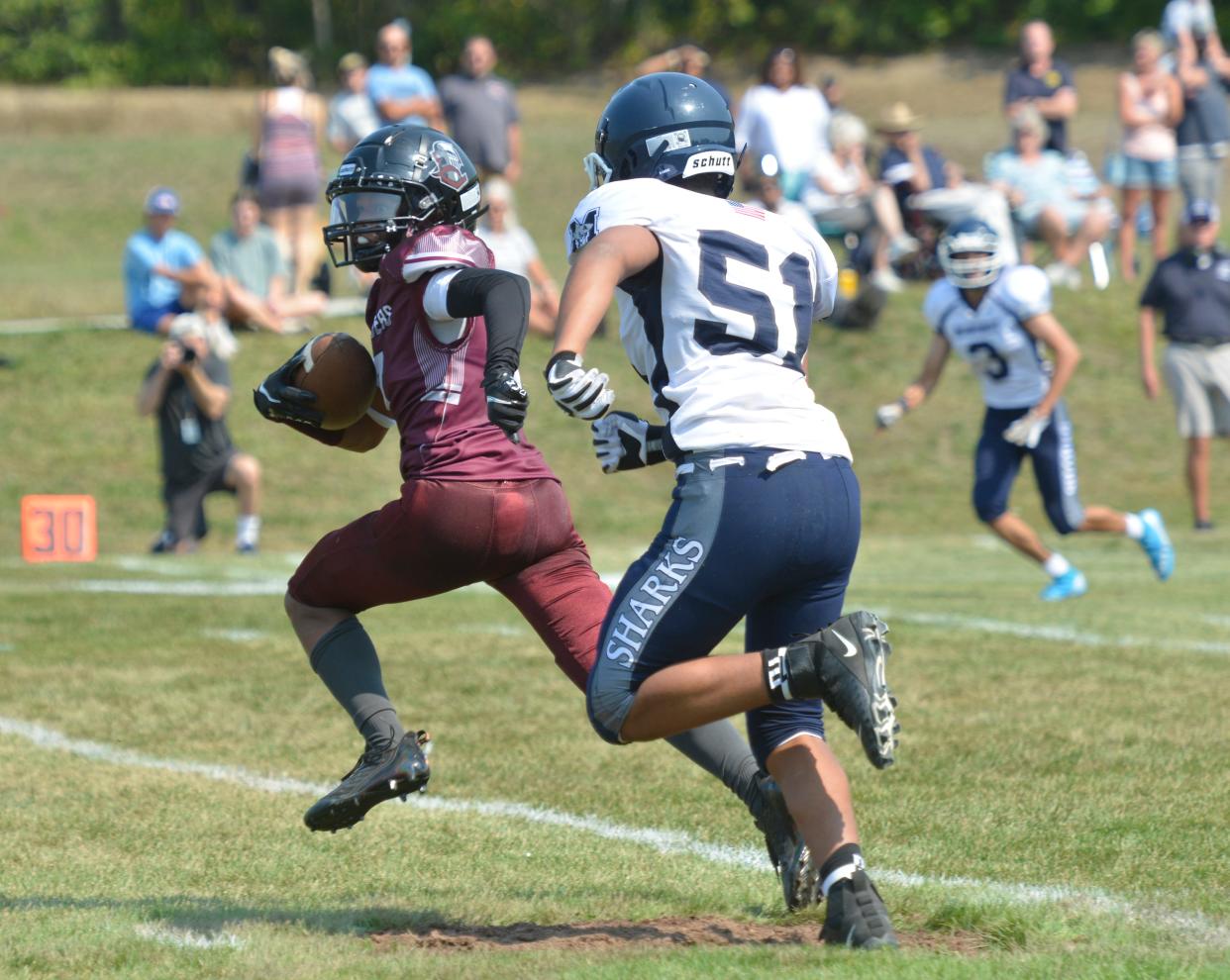 Cape Tech's Sean Gillette, left, looks toward the goal line before being tackled by Monomoy's Sean Needham in a second quarter play.