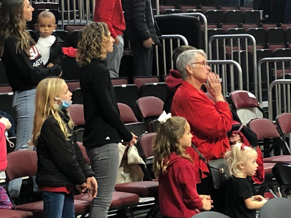 Kathy Barone (standing, right), fights tears as Bradley University pays tribute to her husband, late former BU assistant coach Tony Barone, while her grandchildren Cecilia, Gianna and Ava and SIUE coach Brian Barone's wife, Mimi, look on before BU's 80-55 win at Carver Arena on Saturday, Dec. 4, 2021.