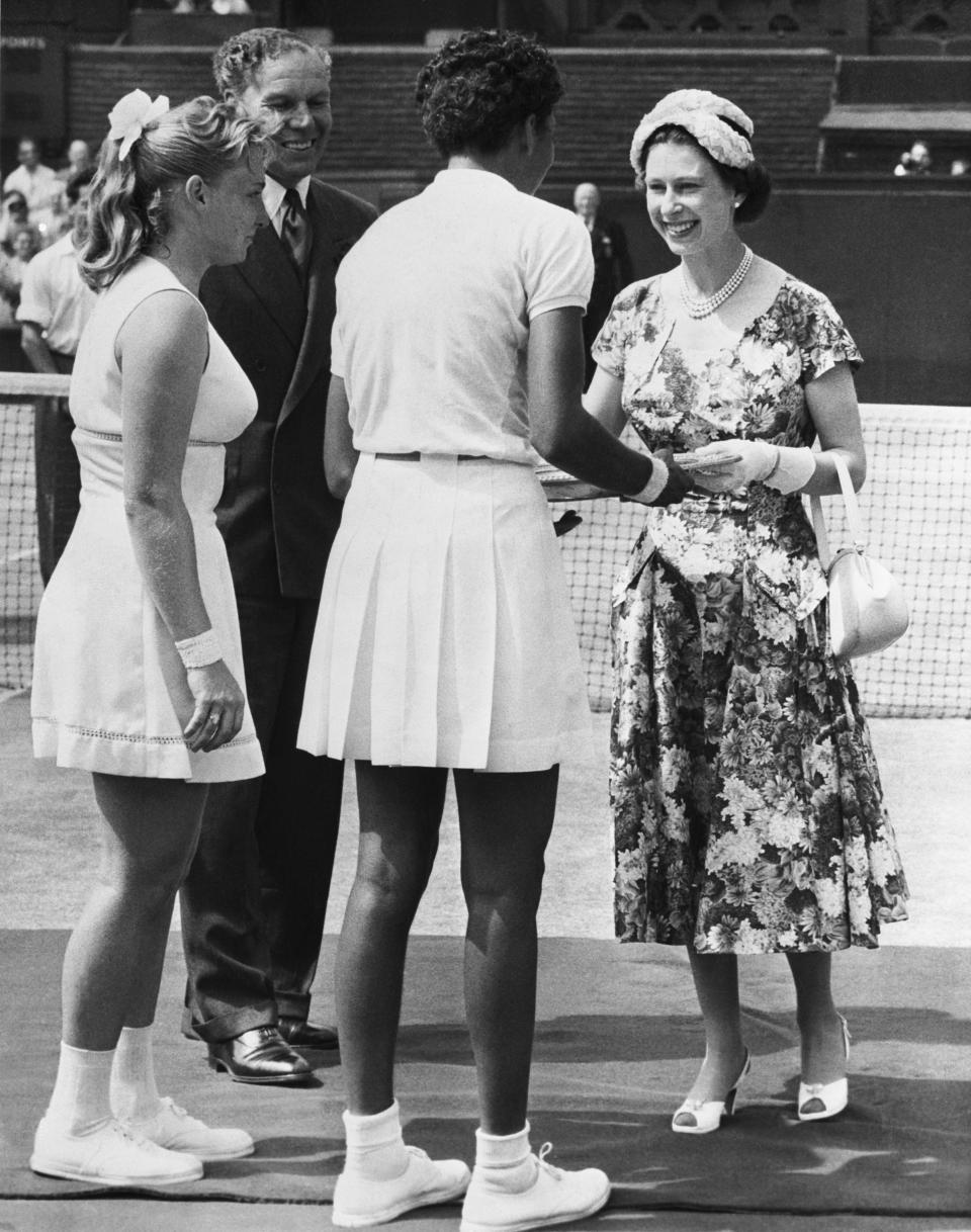 <p>Queen Elizabeth II presented the trophy to American tennis player, Althea Gibson, at her debut Wimbledon tournament. <em>[Photo: Getty]</em> </p>