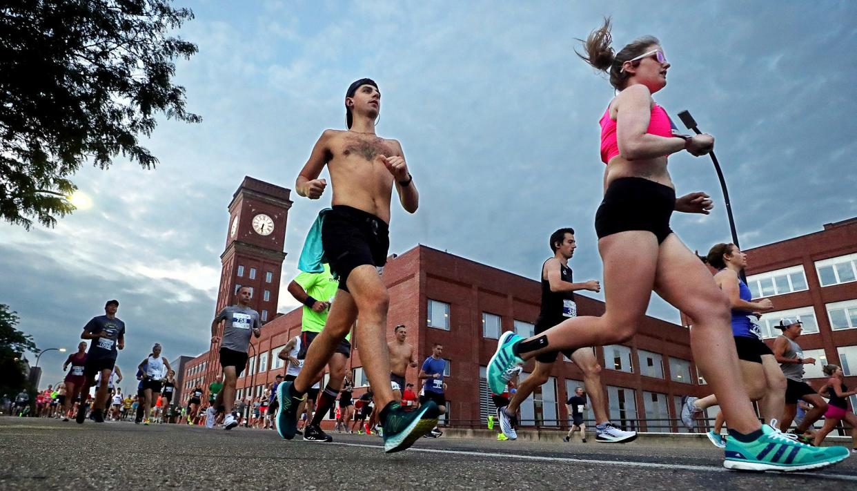 Athletes run past the Goodyear Headquarters during the Goodyear Half Marathon and 10K, Saturday, Aug. 14, 2021, in Akron, Ohio.