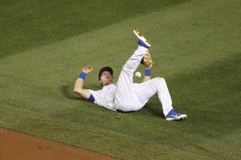 Chicago Cubs shortstop Nico Hoerner loses control of the ball on a base hit single off the bat of Milwaukee Brewers' Brock Holt during the fifth inning of a baseball game against the Milwaukee Brewers Friday, Aug. 14, 2020, in Chicago. (AP Photo/Jeff Haynes)