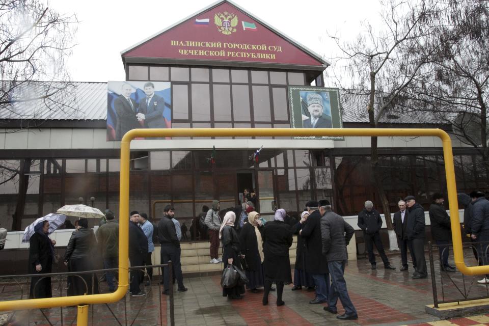 People gather in front of the court building before a hearing on Oyub Titiev, the head of a Chechnya branch of the prominent human rights group Memorial, in Shali, Russia, Monday, March 18, 2019. Oyub Titiyev was detained in January 2018 and charged with drug possession in what has been largely perceived as a vendetta against this rare critic of the Chechen government. The court is due to issue its verdict Monday. (AP Photo/Musa Sadulayev)