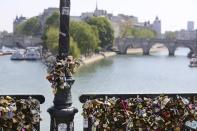 Love locks are fixed on the Pont des Arts in Paris, Wednesday April 16, 2014. A recent fad among travellers of hitching padlocks on bridges and at tourist attractions worldwide to symbolically immortalize their amorous attraction has swept up this reputed City of Love more than most. Now, two American-born women who live in Paris say they've had enough, launching a petition drive to try to get mostly laissez-faire city officials to step in and do something about what they call an unbearable eyesore in a majestic municipality. (AP Photo/Remy de la Mauviniere)