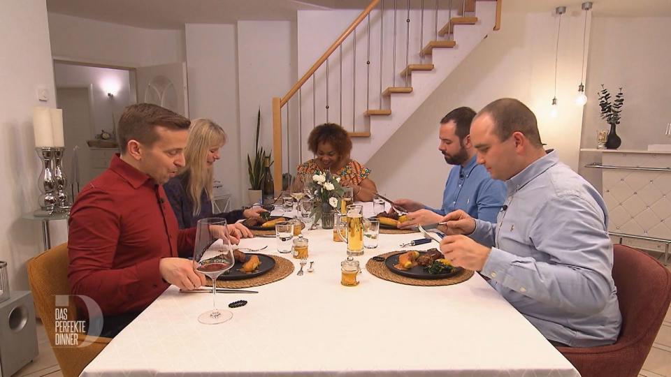 Yvettes (Mitte) Gäste (von links:) Thorsten, Sigi, Mario und Simon sind gespannt, wie die Kochbanane mit Erdnusssoße wohl schmeckt. (Bild: RTL)