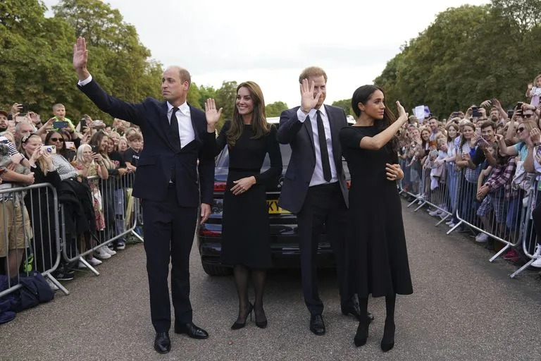 Desde la izquierda, el pr&#xed;ncipe brit&#xe1;nico Guillermo, pr&#xed;ncipe de Gales, Kate, princesa de Gales, el pr&#xed;ncipe Harry y Meghan, duquesa de Sussex saludan a los miembros del p&#xfa;blico en el castillo de Windsor, tras la muerte de la reina Isabel II el jueves, en Windsor, Inglaterra, el s&#xe1;bado 10 de septiembre de 2022.