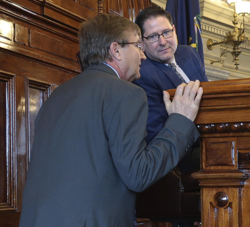 Kansas House Insurance Committee Chairman Jene Vickrey, left, R-Louisburg, confers with House Speaker Ron Ryckman Jr., R-Olathe, during a debate on an insurance bill, Friday, April 5, 2019, at the Statehouse in Topeka, Kan. The bill allows the Kansas Farm Bureau to provide health coverage to its members that doesn't comply with the federal Affordable Care Act. (AP Photo/John Hanna)