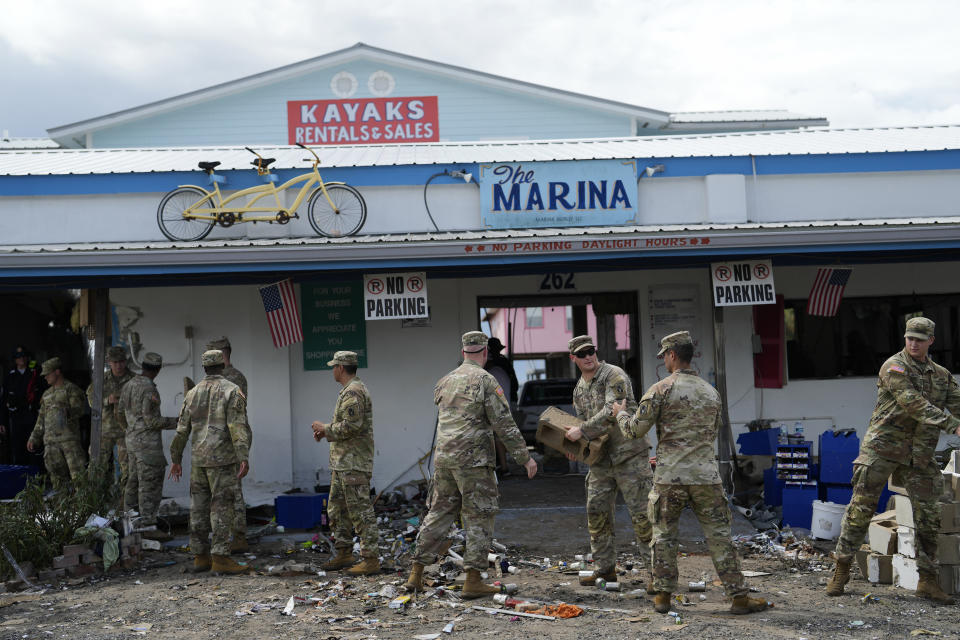 Miembros de la Guardia Nacional ayudan al negocio The Marina, dañado por el huracán Idalia, en Horseshoe Beach, Florida, el 31 de agosto de 2023. (Foto AP/Rebecca Blackwell)